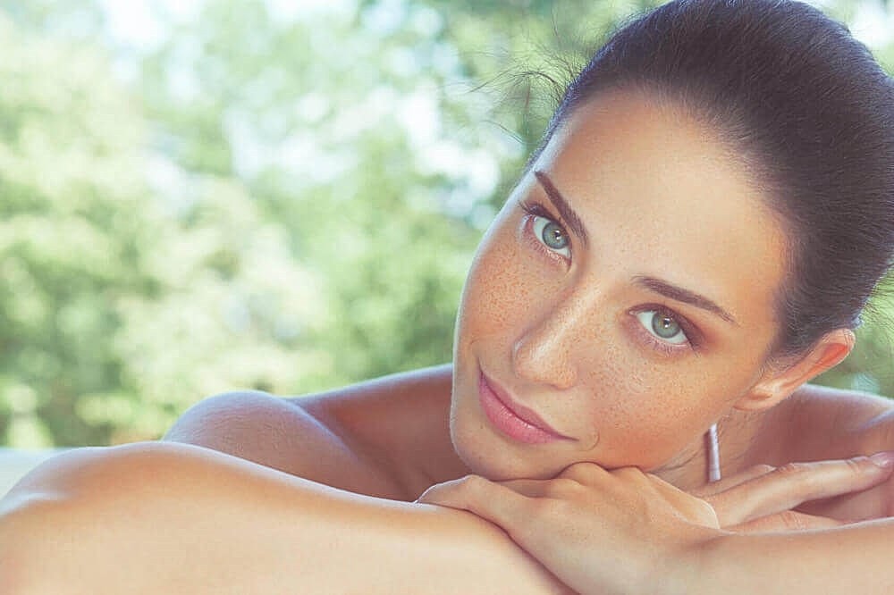 Close-up of woman with green eyes and freckles.