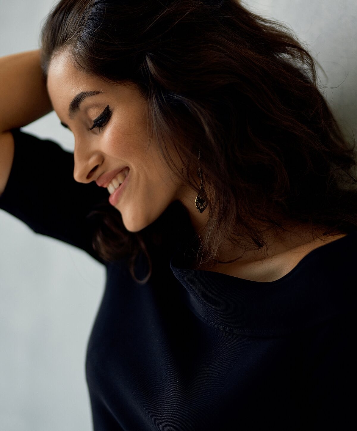 Model striking a pose against a textured wall.