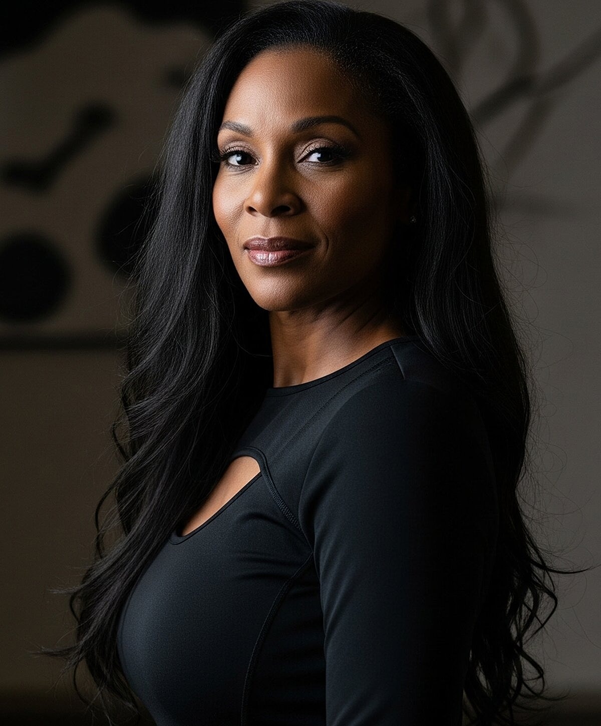 Model posing in neutral-colored lingerie against backdrop.