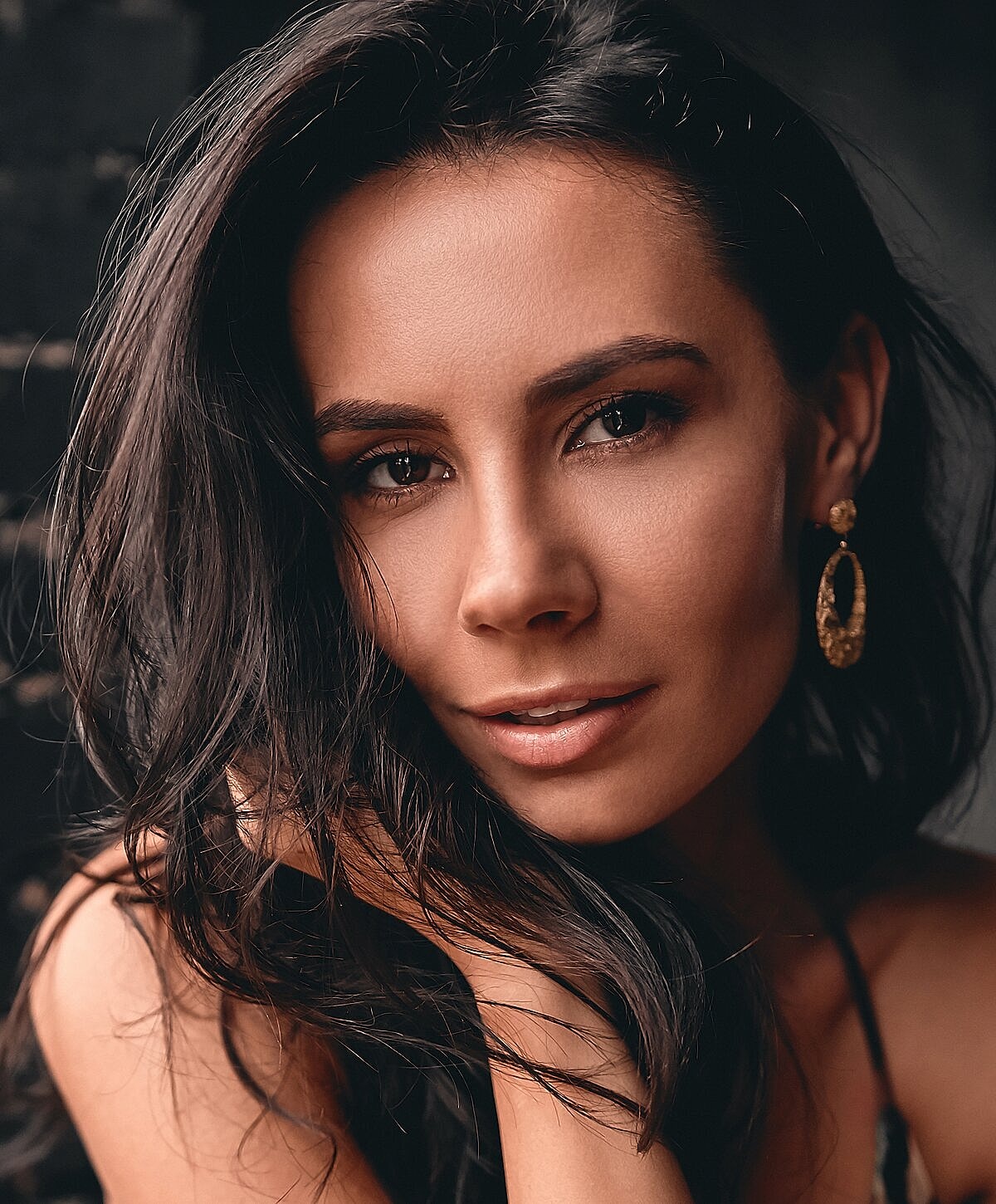 Model striking a pose against a textured wall.
