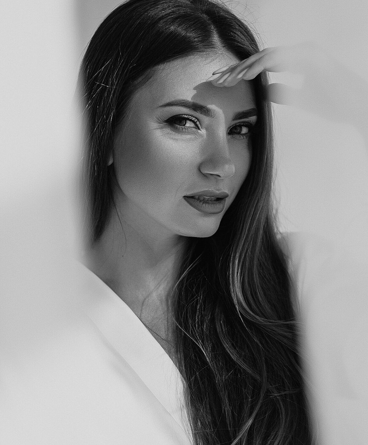 Model striking a pose against a textured wall.