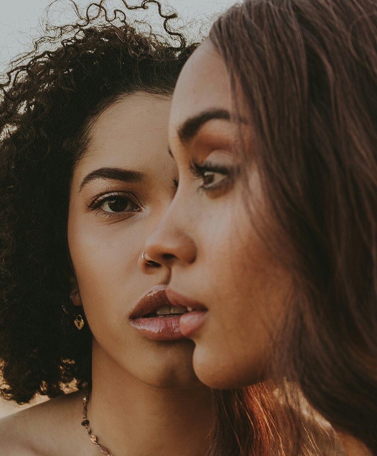 Model posing in neutral-colored lingerie against backdrop.