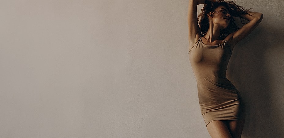 Woman striking a pose against a neutral background.