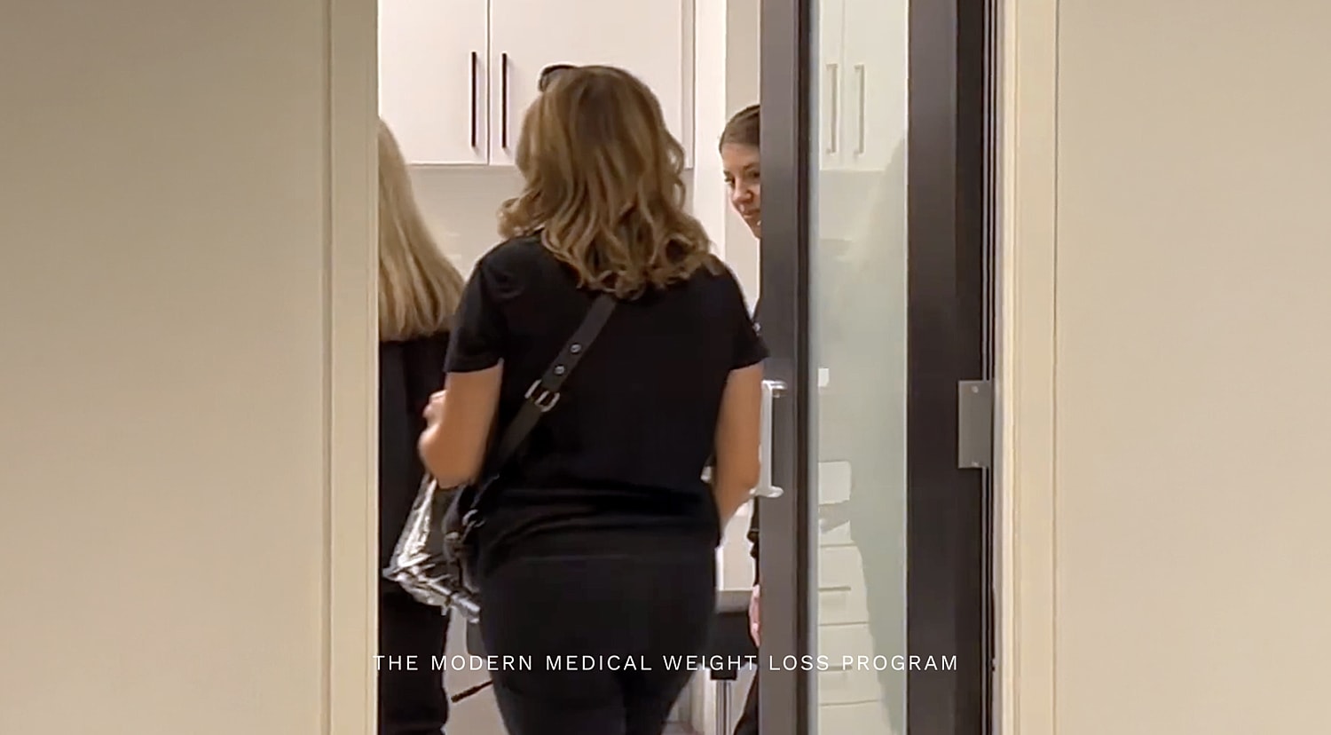 Women in black clothing entering a consultation room.